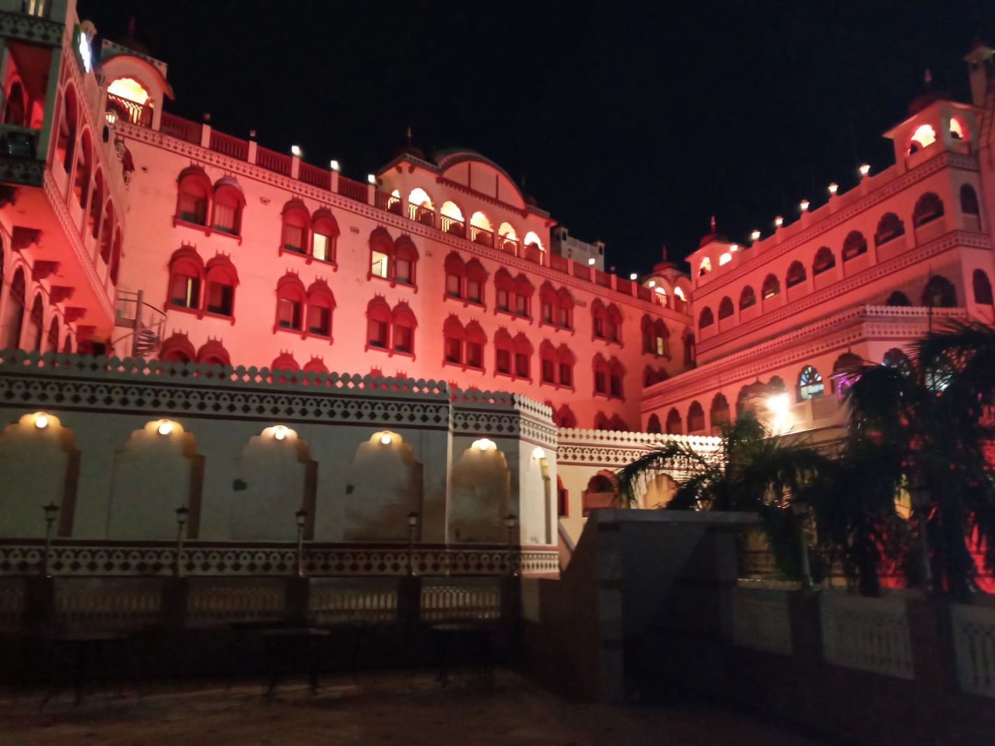 Fort Chandragupt Hotel heritage facade lit in red at night, Jaipur