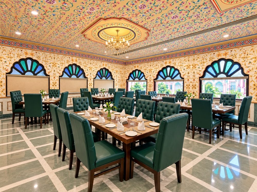 Restaurant interior with ornately painted ceiling and dining tables at Fort Chandragupt Hotel Jaipur