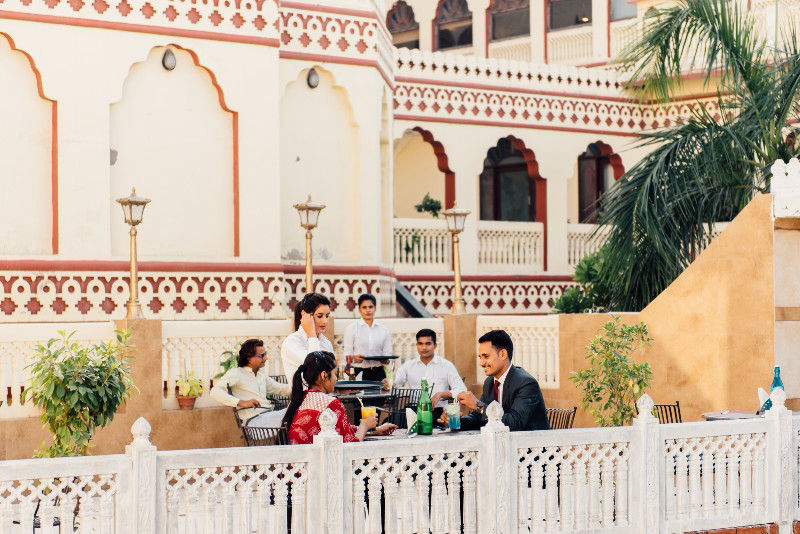 Rooftop terrace dining service with heritage building backdrop at Fort Chandragupt Hotel Jaipur