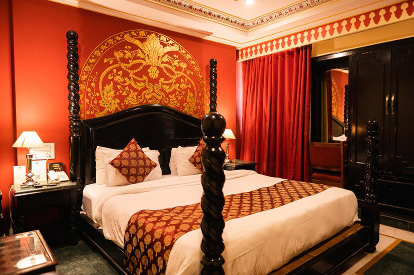 Suite Room with ornate heritage-style headboard and decor at Fort Chandragupt Hotel Jaipur