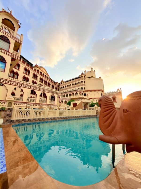 Rooftop swimming pool with elephant fountain at sunset at Fort Chandragupt Hotel Jaipur