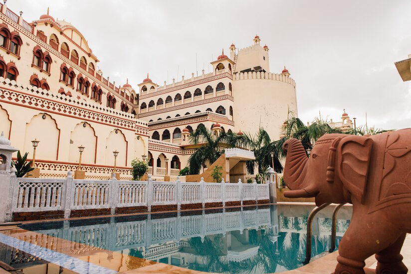 Outdoor swimming pool with carved elephant statue at Fort Chandragupt Hotel Jaipur